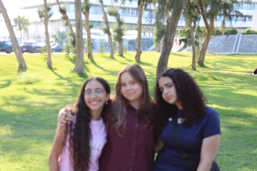 Three Interact Agora members standing together in the park