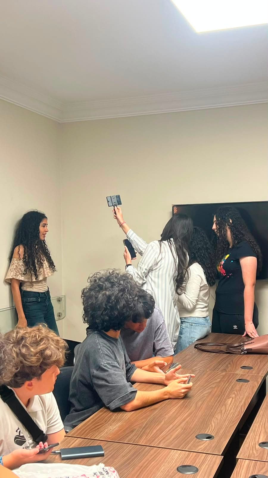 Members filming with a phone gimbal in the club meeting room
