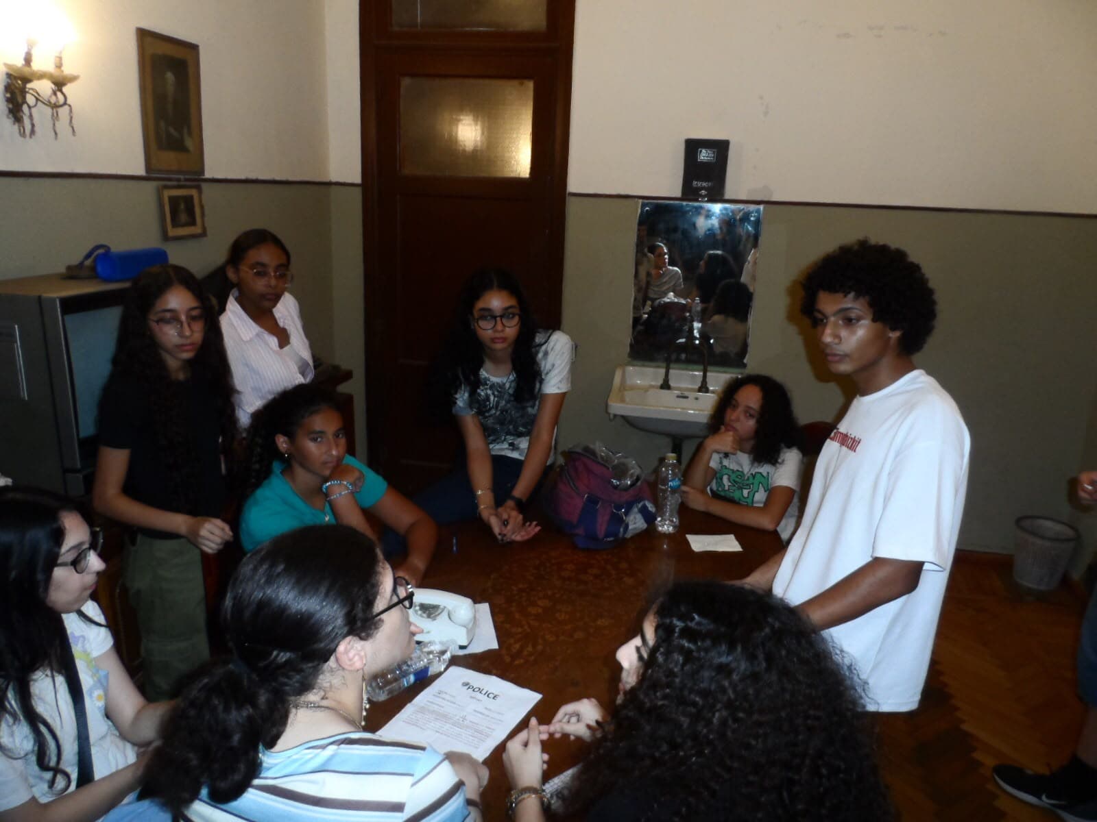 Members gathered around a round table with a police-themed case file during the murder mystery